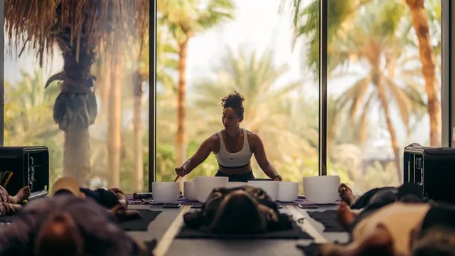 A sound-healing session with crystal bowls and palm trees through the windows.